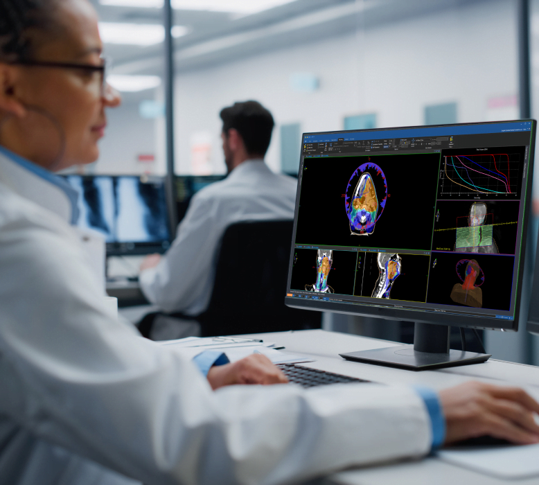A clinician reviewing a radiation treatment plan at a planning workstation